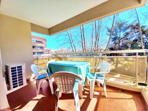 un balcon avec une table et des chaises et une grande fenêtre dans l'établissement Studio Cosy Fréjus Plage - Clim, WIFI & Parking, à Fréjus