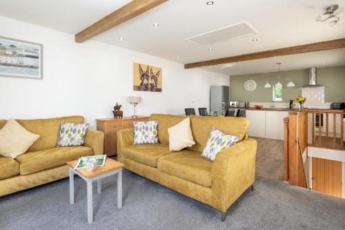 a living room with two couches and a kitchen at Church House Barn Lake District & Solway Coast with Solway Firth views in Silloth