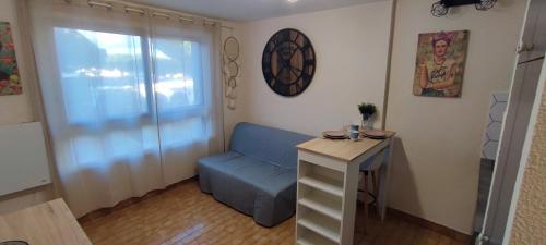 une petite pièce avec un banc bleu et une table dans l'établissement Studio Les Floralies 2 du Grau du Roi, au Grau-du-Roi
