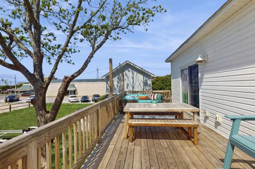 a wooden deck with a picnic table and a tree at The Salty Pecan in Morehead City