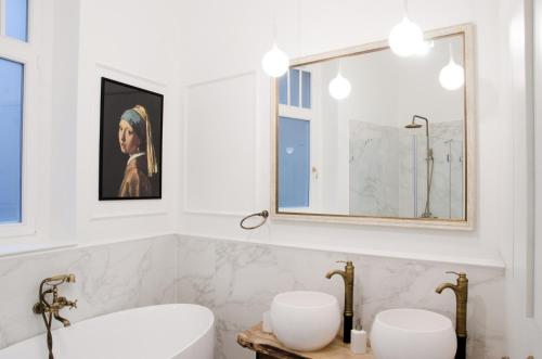 a bathroom with two sinks and a mirror at Luxury Apartment by Hi5 - Best Location 3-br in Budapest