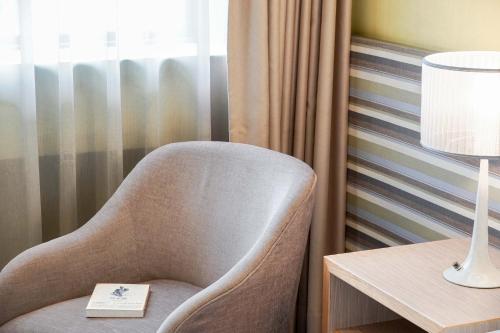 a chair sitting next to a table with a lamp at 塔木德酒店 台中火車站館 Talmud Hotel Taichung Station in Taichung