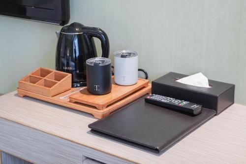a counter top with a coffee maker and a coffee pot at 塔木德酒店 台中火車站館 Talmud Hotel Taichung Station in Taichung