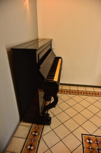 a piano sitting in a corner of a room at Liberty House in Turbigo