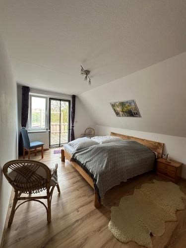 a bedroom with a bed and a chair and a window at Marienwarder in Lehmkuhlen