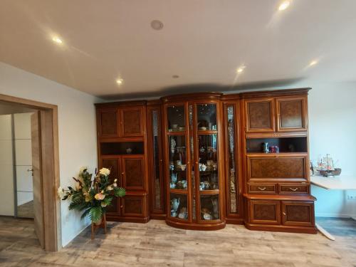 a kitchen with wooden cabinets and a vase of flowers at VipStay - Stilvoll und geräumige Apartments mit Terasse oder Balkon, Küche, kostenloses Parken, WLAN, Smart Tv in Wiesloch