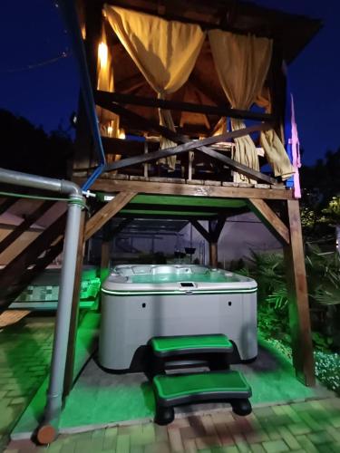 a hot tub on a patio at night at Unicum Vendégház in Abádszalók