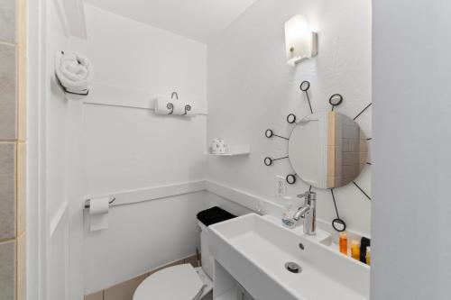 a white bathroom with a toilet and a mirror at Atomic Motel in Moab