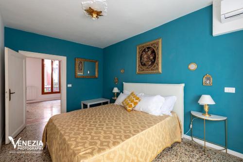 a bedroom with a large bed with blue walls at Ampia Casa a due passi dalla Biennale in Venice