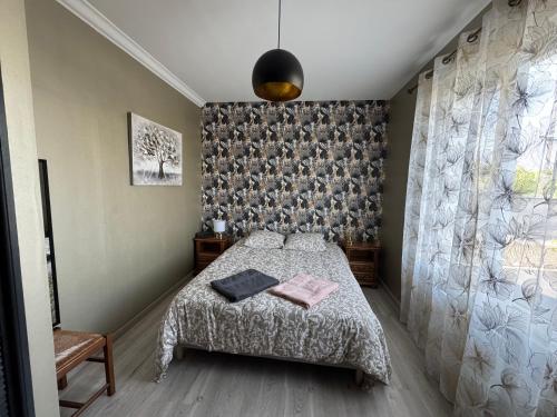 une chambre avec un lit et un mur dans l'établissement Maison, à Longueville