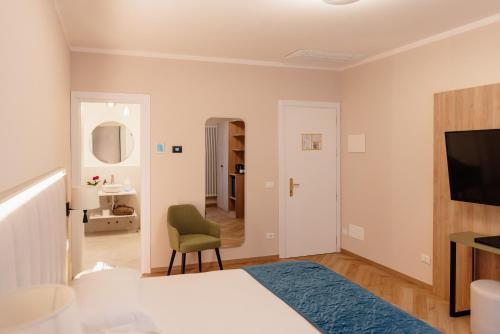 a bedroom with a bed and a chair and a television at Hotel Due Palme in Mergozzo