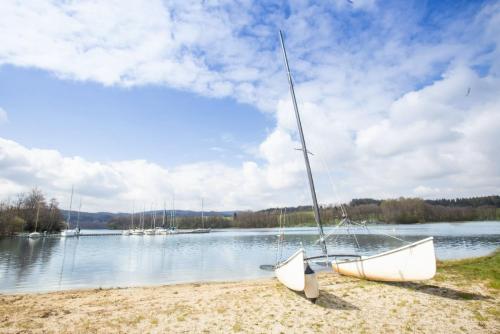 a sail boat sitting on the shore of a lake at Apartmán v areálu Wellness hotel Frymburk in Frymburk