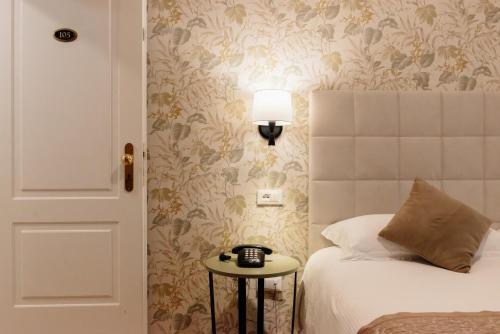 a bedroom with a bed and a table with a lamp at Hotel Due Palme in Mergozzo