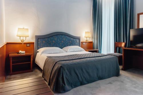 a hotel room with a bed and a television at Hotel Due Palme in Mergozzo