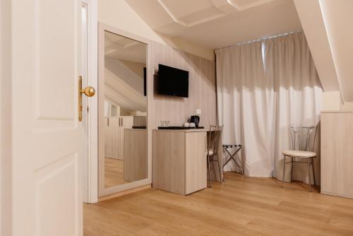 a room with a kitchen with a table and a mirror at Hotel Due Palme in Mergozzo