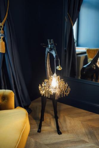 a statue of a goat with a light on a table at Aparthotel Amella in Rīga