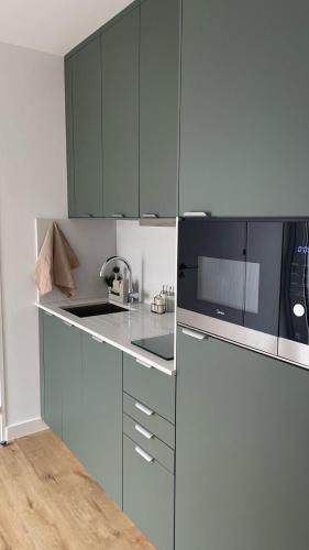 a kitchen with blue cabinets and a sink and a microwave at Casinha de Roliça in Roliça