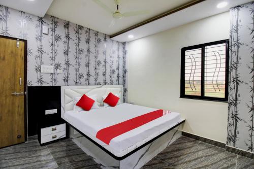 a bedroom with a bed with red pillows and a window at Hotel O One Plus Inn in Itwāri