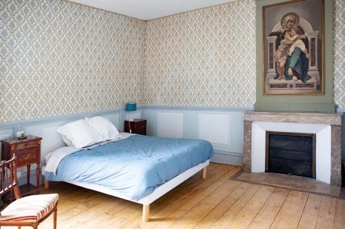 une chambre avec un lit et une cheminée dans l'établissement Chateau de Maisonneuve, à Leigné-les-Bois