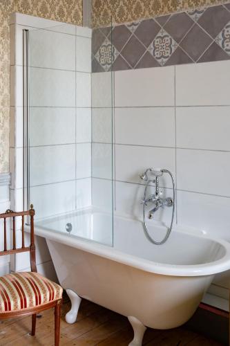 La salle de bains est pourvue d'une baignoire et d'une chaise. dans l'établissement Chateau de Maisonneuve, à Leigné-les-Bois