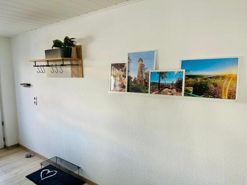 a room with pictures on a white wall at Ferienwohnung Karl im schönen Pfälzer Wald in Petersberg