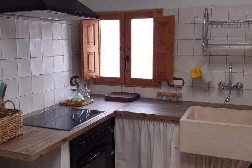 a kitchen with a sink and a counter top at Casita rural Els voladorets in Torre de Endoménech