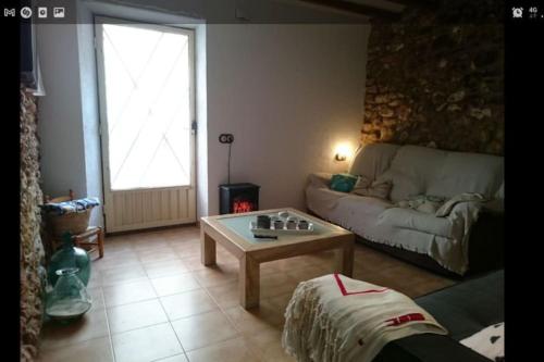 a living room with a couch and a coffee table at Casita rural Els voladorets in Torre de Endoménech