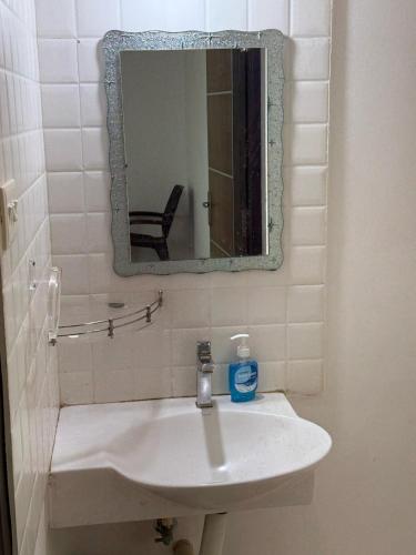 a bathroom with a white sink and a mirror at Hope in Udupi