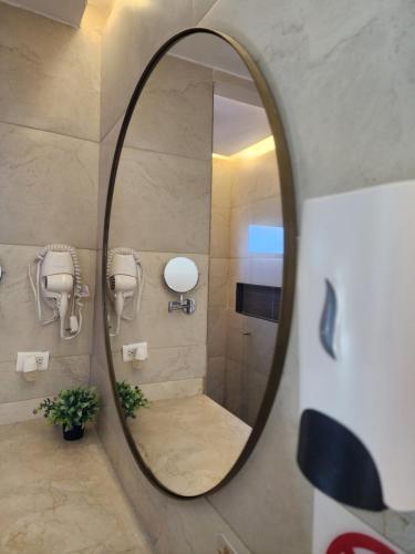 a mirror in a bathroom with a shower at Hotel y Cabañas Covemar in Coveñas