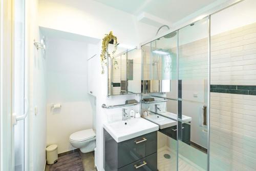 Appartement Place Monge 3 Guests في باريس: حمام مع حوض ودش زجاجي