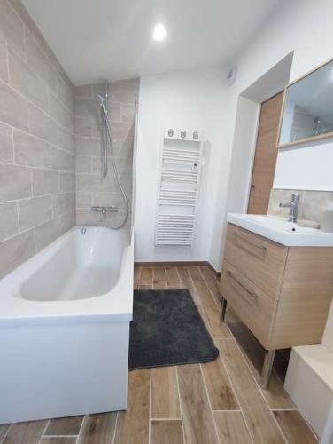 une salle de bain blanche avec une baignoire et un lavabo dans l'établissement Gîte à la campagne, à Fiquefleur-Équainville