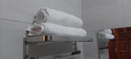 a stack of towels on a shelf in a bathroom at Serene BnB - Apt 06 Makongo after Mlimani City in Dar es Salaam