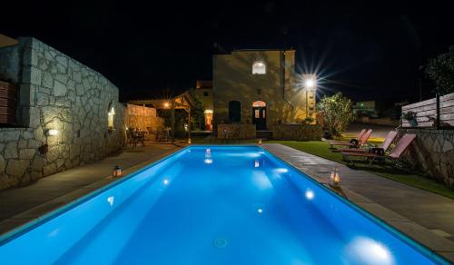 a swimming pool in a yard at night at Skandalis Apartments with pool in Chorafakia