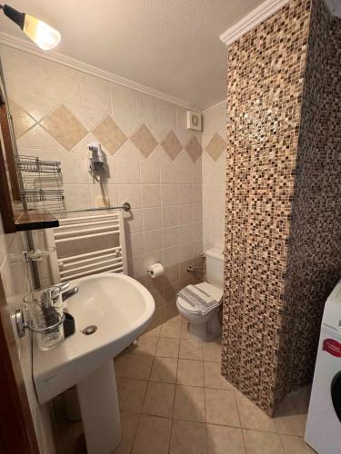 a bathroom with a sink and a toilet at Skandalis Apartments with pool in Chorafakia