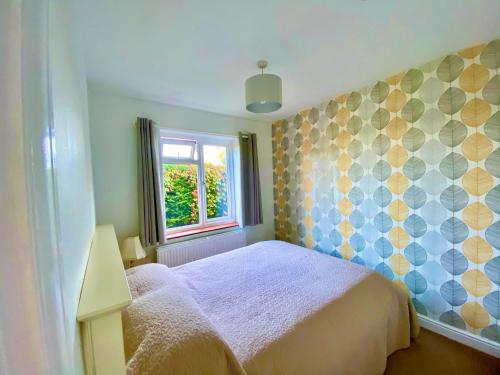 Un dormitorio pequeño con una cama y una ventana. en Pound Corner, en Godalming