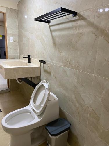 a bathroom with a white toilet and a sink at Hotel y Cabañas Covemar in Coveñas