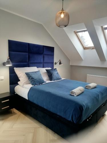a bedroom with a blue bed with two towels on it at Apartament przy Zodiaku in Mrągowo