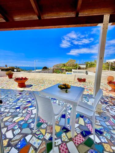 a table and chairs on a beach with a mosaic floor at Villa Egidio in Ischia