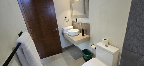 a small bathroom with a toilet and a sink at Cabañas los Cedros in Santiago Oxtempan
