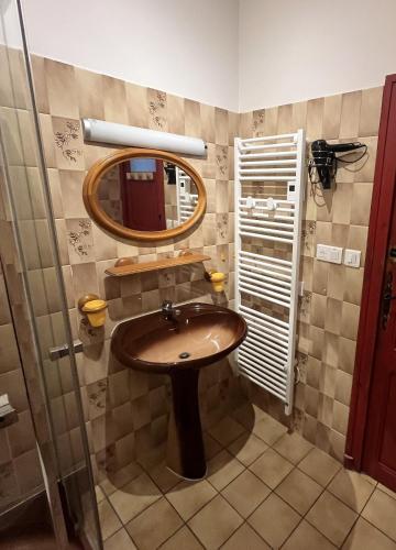 une salle de bain avec un lavabo et un miroir dans l'établissement Les Bancs d'Autrefois, maison climatisée avec WIFI au centre de Ruoms, à Ruoms