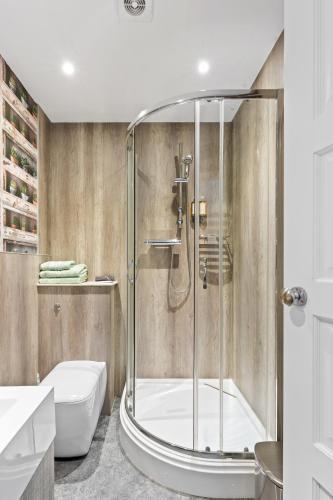 a bathroom with a shower with a tub and a toilet at Falmouth Bay in Falmouth