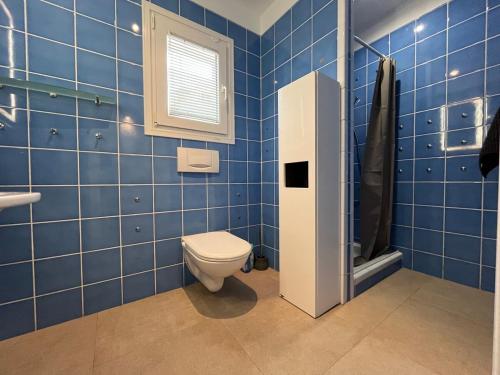 a blue tiled bathroom with a toilet and a sink at Villa Rosita Ibiza in Talamanca