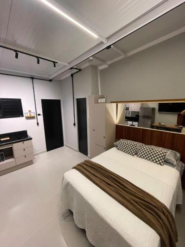 una camera da letto con un letto grande e una cucina di Studio Loft 08 novo e aconchegante, Gaspar centro, 15 minutos de Blumenau a Gaspar