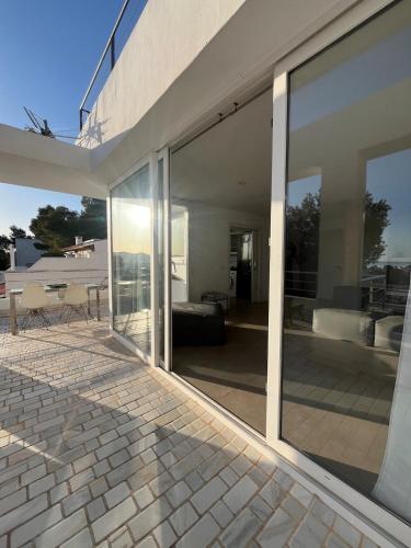 a large glass door of a house with a patio at Villa Rosita Ibiza in Talamanca