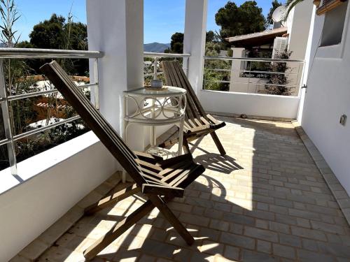 a rocking chair on a balcony with a table at Villa Rosita Ibiza in Talamanca