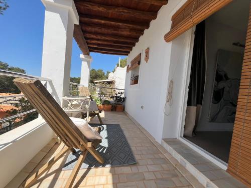 a patio with a rocking chair on a balcony at Villa Rosita Ibiza in Talamanca