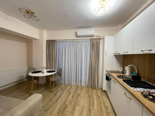 a living room with a table and a kitchen at Ayan Residence in Năvodari