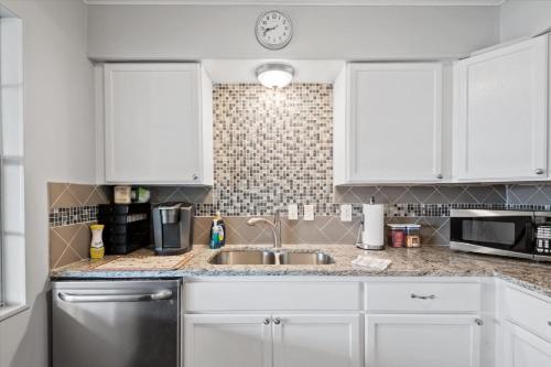a kitchen with white cabinets and a sink at Charming 4BR Lakefront Getaway in Tool