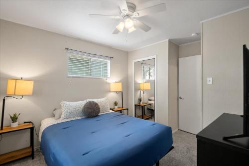 a bedroom with a blue bed and a ceiling fan at Charming 4BR Lakefront Getaway in Tool