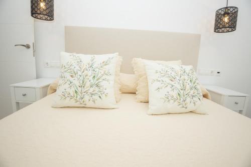 a white bed with white pillows on it at El Templete Suite 2 in Córdoba